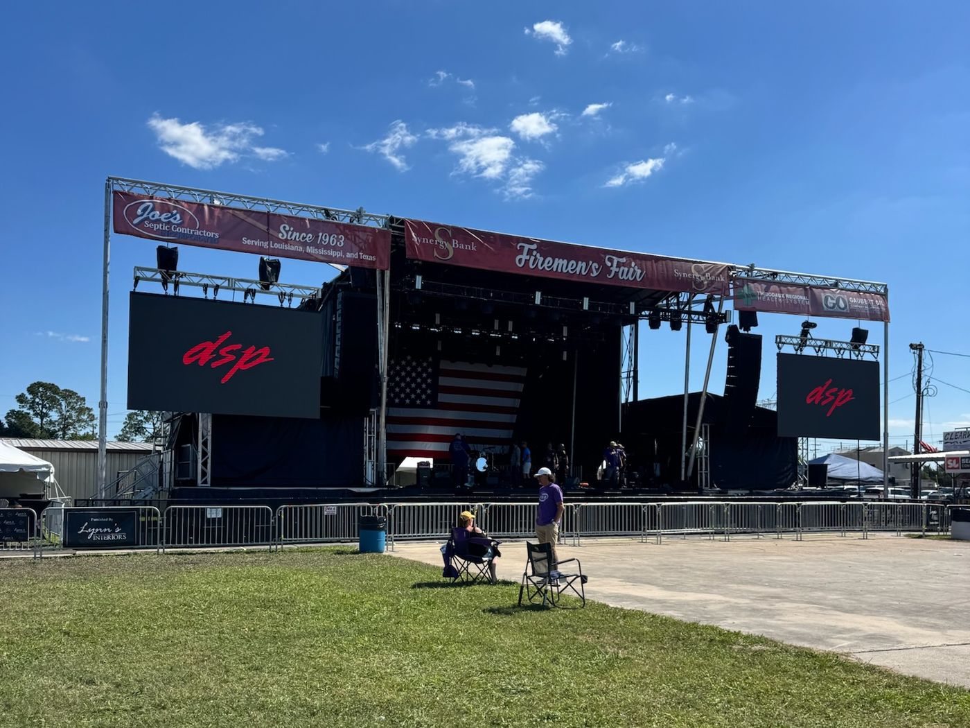 Mobile stage deployed on a grass lot for a community event